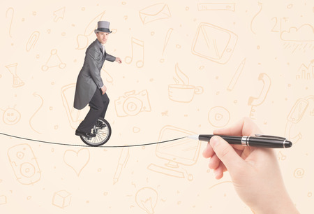 Businessman riding monocycle on a rope drawn by hand conceptの写真素材