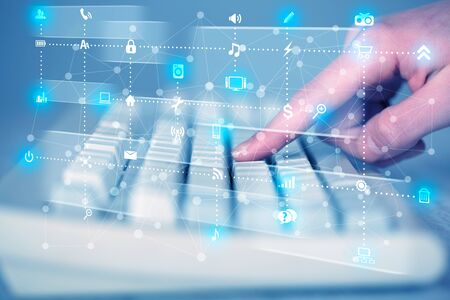 Hand pressing keyboard with high tech media icons and symbols