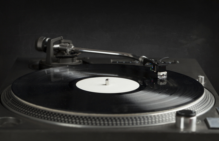 Turntable playing vinyl close up with needle on the record with grey backgroundの写真素材