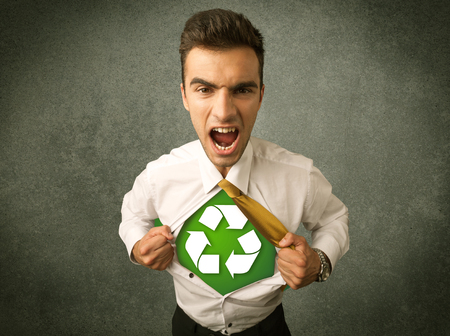 Enviromentalist business man tearing off shirt with recycle sign on his chest concept on backroundの写真素材