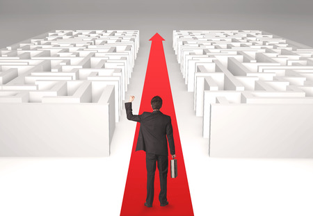 Successful businessman in front of a separated labyrinth, concept about simple solutionの写真素材