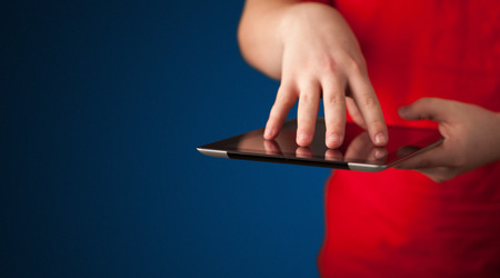 Close up of hand holding digital touchpad tablet device on backgroundの写真素材