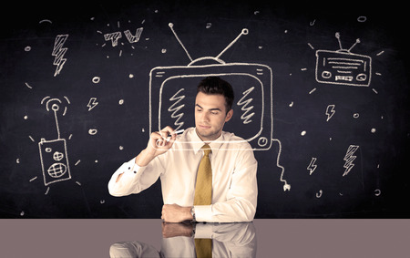 An elegant happy businessman drawing a television around his face, dreaming about becoming a famous actor or a programme presenter conceptの写真素材