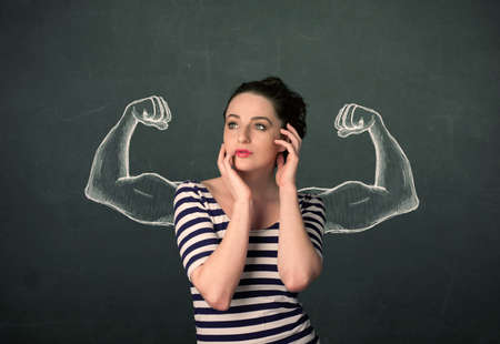 Pretty young woman with sketched strong and muscled armsの写真素材