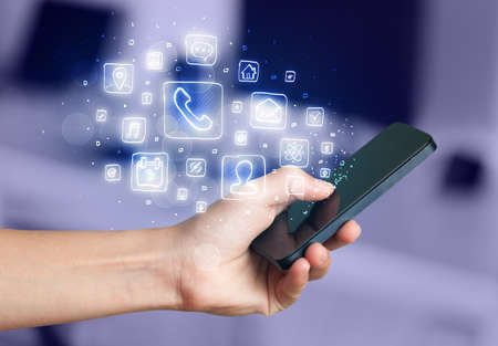 Hand holding smartphone with glowing mobile app icons