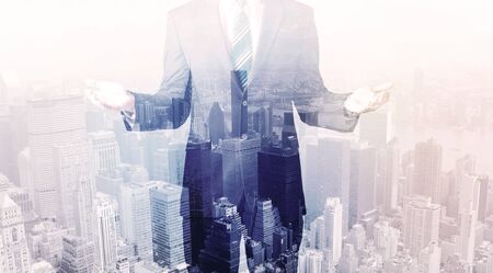 Business man standing on roof with city view in the backgroundの写真素材