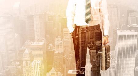 Business man looking at warm overlay city backgroundの写真素材