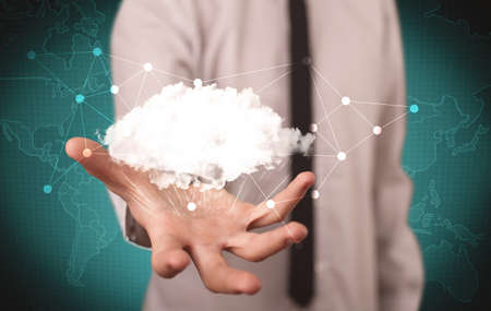 Elegant business person holding an empty white cloud in its hands in front of green wall background with world map illustration conceptの写真素材