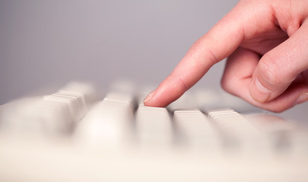 Close up of hand pressing keyboard buttons on deskの写真素材
