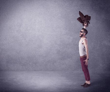 A hipster guy in stylish clothes shouting in front of an empty urban concrete wall background...