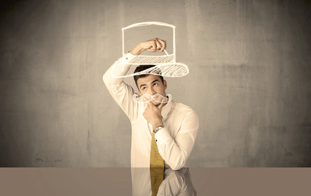 A young happy businessman in elegant suit drawing funny hat and mustache in empty grey space with a chalk illustration conceptの写真素材