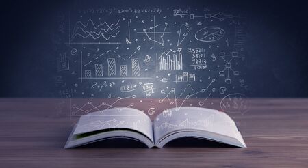 Hand-drawn financial plans and charts coming out of an open bookの写真素材