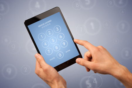 Female fingers touching tablet with locked device requiring passcode