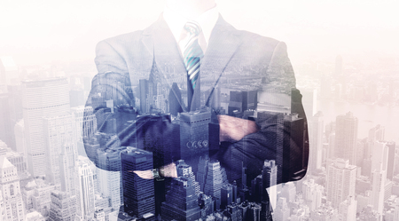 Business man standing on roof with city view in the backgroundの写真素材