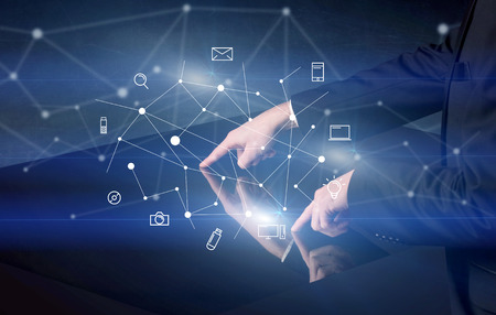 Male hands touching interactive table with blue mixed communication icons in the backgroundの写真素材