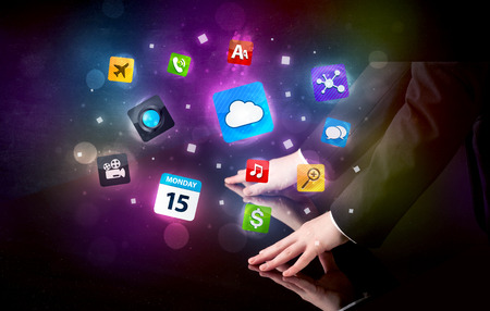 Male hands touching interactive table with colorful application icons on itの写真素材