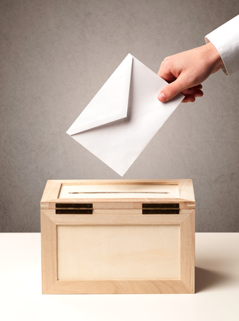 Ballot box with person casting vote on blank voting slip, grungy backgroundの写真素材