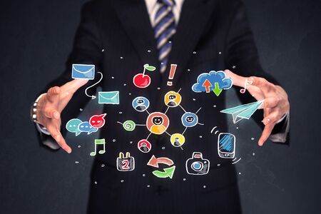 Colorful hand-drawn social media icons in the hands of a businessmanの写真素材