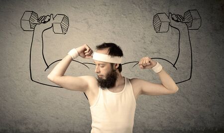 A young college student with beard and glasses posing in front of grey background, thinking about lifting weight with big muscles, illustrated by white drawing concept.の写真素材