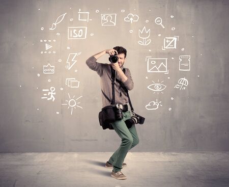 An amateur hobby photographer learning to use a professional digital camera with camera settings icons on the background wall conceptの写真素材