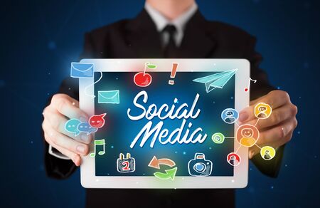 Businessman holding tablet with social media iconsの写真素材