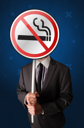 Smart businessman holding round sign with no smoking graphicの写真素材