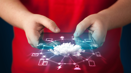 Close up of hand holding tablet with cloud network technology concept on backgroundの写真素材