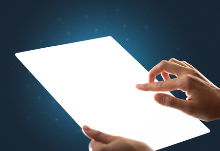 Young female hand holding and touching a piece of glass meant to look like a tabletの写真素材