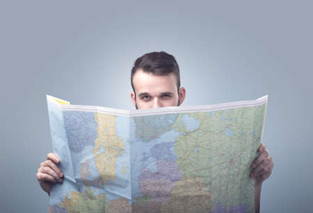 Handsome young man holding mapの写真素材