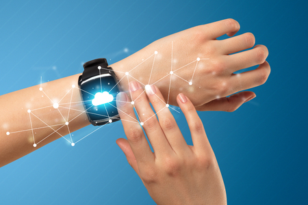 Female hand with smartwatch and with cloudy  icons on it.の写真素材