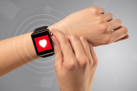 Female hand with smartwatch and with heart rate icon on it.の写真素材