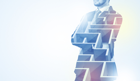 Businessman in suit staying with maze on the background.の写真素材