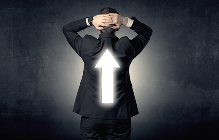 Young businessman standing and thinking about which direction to chooseの写真素材