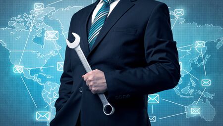 Businessman holding tool with global map graphic on the backgroundの写真素材