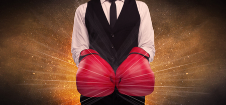 A successful powerful business person in red boxing gloves concept with illustrated power lines and pieces falling apart in front of explosion.の写真素材