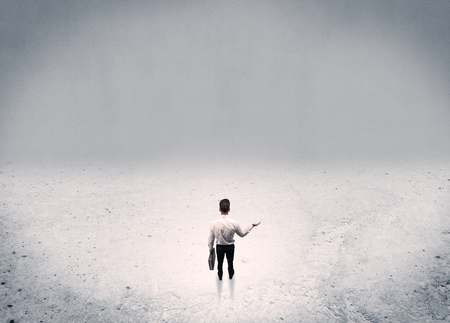 An adult elegant businessman standing in the middle of nowhere in empty grey concrete space background conceptの写真素材