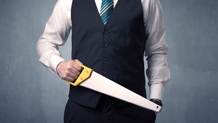 Young, handsome, cute businessman holding tool with grey backgroundの写真素材