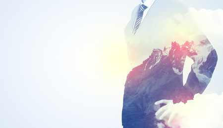 Businessman standing and thinking with snowy mountain graphicの写真素材