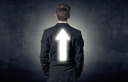 Young businessman standing and thinking about which direction to chooseの写真素材