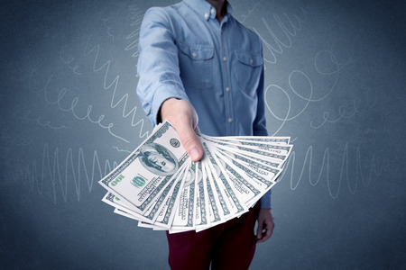 Young businessman holding large amount of bills with grungy backgroundの写真素材