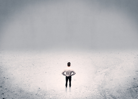 An adult elegant businessman standing in the middle of nowhere in empty grey concrete space background conceptの写真素材