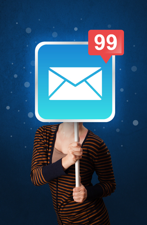 Casual young woman holding square sign with mail iconの写真素材