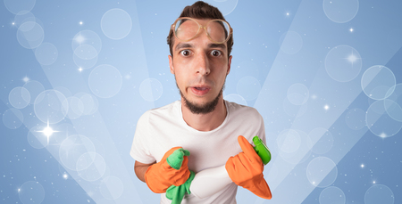 Glittered blue background with male housekeeper and cleaning equipmentの写真素材