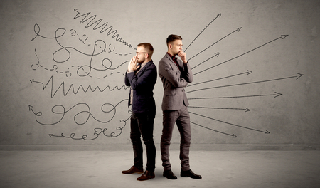 Young conflicted businessman choosing between two directions with arrows and scribbles around himの写真素材