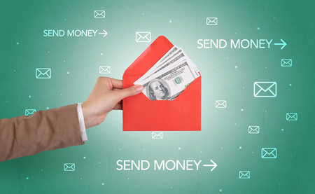 Female hand holding empty and full envelope with green background and symbols aroundの写真素材