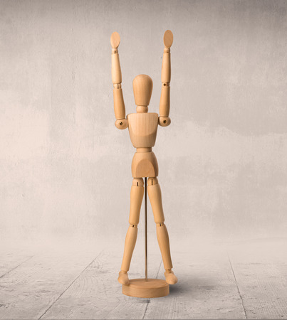 Wooden mannequin posed in front of a greyish backgroundの写真素材