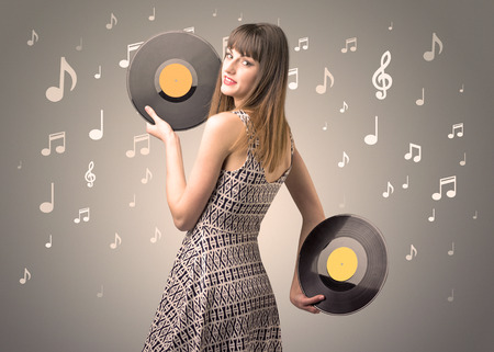 Young lady holding vinyl record on a brown background with musical notes behind her