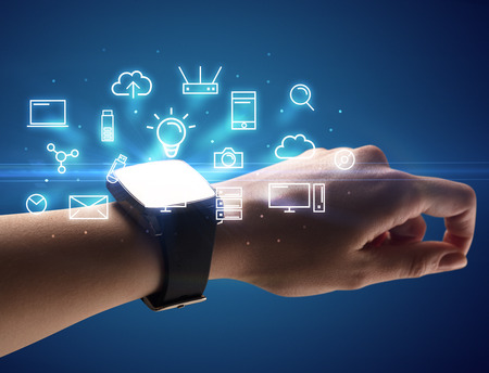 Close up female hand with smartwatch and multimedia symbols around and blue backgroundの写真素材