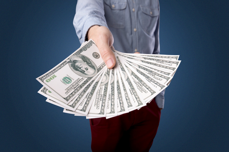Young businessman holding large amount of billsの写真素材