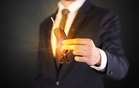 Formal man hand over shiny keys with dark backgroundの写真素材